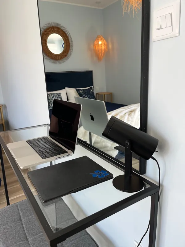 Glass desk with a mirror, set up for working remotely